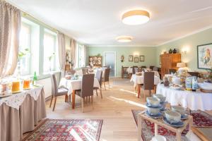 een eetkamer met witte tafels en stoelen bij Donauhof - Hotel garni in Weissenkirchen in der Wachau
