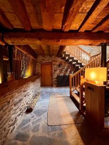 an attic room with stairs and a stone wall at Cobert de Felip 