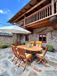 a wooden table with chairs and an umbrella on a patio at Cobert de Felip 