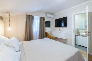 a hotel room with a white bed and a bathroom at Turta Rooms in Zadar +17 photos