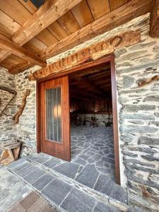 a building with a wooden door and a stone wall at Cobert de Felip 