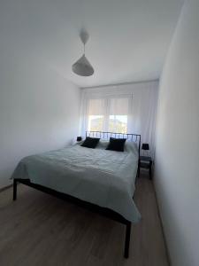 - une chambre blanche avec un lit dans l'établissement Apartament nad Iławką, à Iława