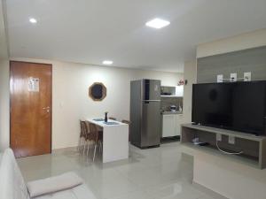 sala de estar con TV y cocina en Nomar XI - Gold Flat, en João Pessoa