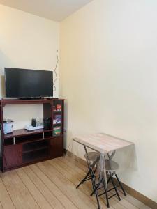 a living room with a table and a television at SAN JOSE DEL MONTE BULACAN GUMAOK West,Delgados Place UNIT 2 in Mangangpico