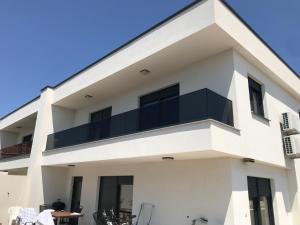 a white building with a balcony at Apartman Mara Vodice in Vodice