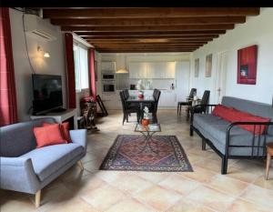 a living room with two couches and a dining room at Ferme Binel à Ronsac in Aigrefeuille