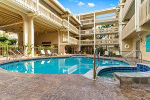 a swimming pool in the courtyard of a building with a hotel at Kona Bali Kai #165 in Kailua-Kona