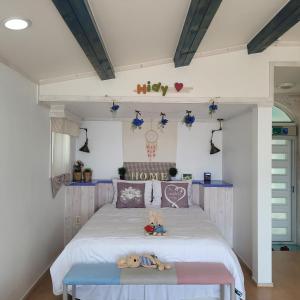 Un dormitorio con una cama y una mesa con animales de peluche. en Soulmate Pension, en Namhae