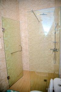 a shower with a glass door in a bathroom at House 475 Apartments. in Abuja