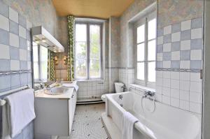 a bathroom with a tub and a sink and a bath tub at Le Grand Monarque in La Charité-sur-Loire