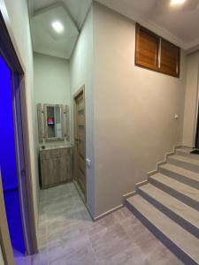a hallway with a staircase with a door and a television at KosMos Guest House in Gyumri