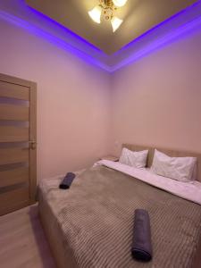 una camera con due letti e luci viola sul soffitto di KosMos Guest House a Gyumri