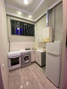 una piccola cucina con piano cottura e frigorifero di KosMos Guest House a Gyumri