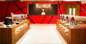 a restaurant with red walls and a counter with dishes at Camelot Beach Hotel in Negombo