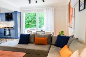 Private Villa With Garden Near Beaches in Marmaris في مرماريس: غرفة معيشة مع أريكة مع وسائد برتقالية وزرقاء