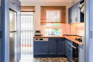 Private Villa With Garden Near Beaches in Marmaris في مرماريس: مطبخ به دواليب زرقاء وعدادات زرقاء