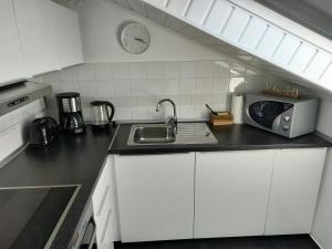 cocina con fregadero y microondas en Möwenkoje -klimatisiert- en Alsum