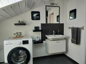 y baño con lavadora y lavamanos. en Möwenkoje -klimatisiert- en Alsum