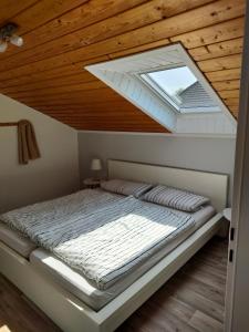 a bedroom with a bed with a skylight at Möwenkoje -klimatisiert- in Alsum