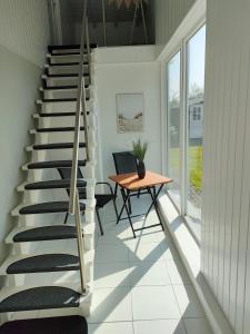 Una escalera en una casa con mesa y escritorio en Möwenkoje -klimatisiert- en Alsum