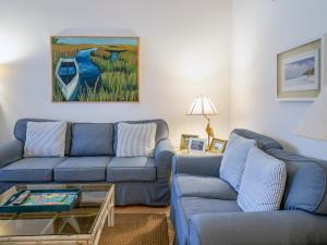 a living room with two blue couches and a painting at 2780 Live Oak Villa in Seabrook Island