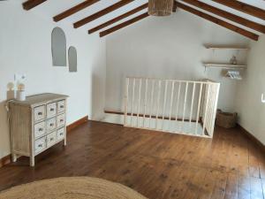 an attic room with a wooden floor and a dresser at Casa Maria Flora in Ojén
