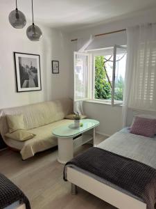 un soggiorno con divano e tavolo di Center town apartment Lipa Mala a Gradac (Grado)