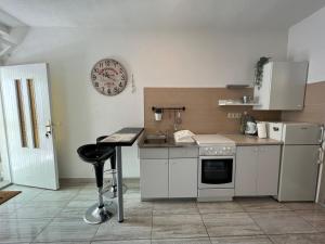 una cucina con piano cottura, lavandino e orologio di Center town apartment Lipa Mala a Gradac (Grado)