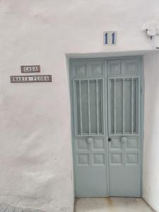 un edificio bianco con una porta con un cartello sopra di Casa Maria Flora a Ojén
