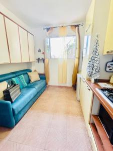 ein Wohnzimmer mit einer blauen Couch in einer Küche in der Unterkunft Petit in Porto Ercole