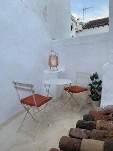 2 sedie e un tavolo e una lampada su un patio di Casa Maria Flora a Ojén