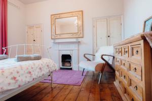 テンビーにあるNo4 Queens Parade close to Tenby South Beachのベッドルーム(ベッド1台、暖炉、鏡付)