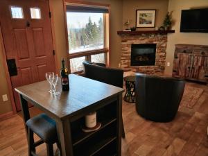 a living room with a table with wine glasses and a fireplace at MyLutsen in Lutsen