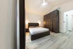 a bedroom with a bed and a large brown headboard at Kalipe House in Bosa