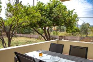 een tafel en stoelen op een balkon met bomen bij DiMaGeo Life studio apartment in Chania