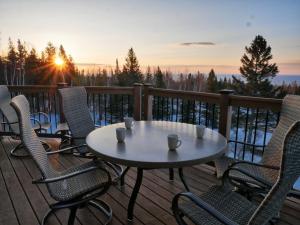 a table and chairs on a deck with the sunset at MyLutsen in Lutsen