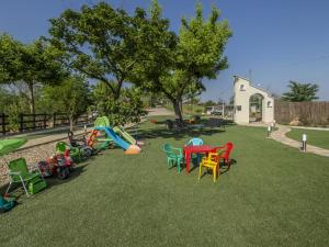 Casa del Rosmarino في آستي: ملعب مع كراسي ملونة وطاولات على العشب