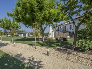 un parc avec des arbres, un banc et une maison dans l'établissement Casa del Rosmarino, à Asti