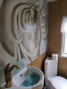 a bathroom with a sink with a woman painted on the wall at Mobilheim in Alttrebbin in Neutrebbin