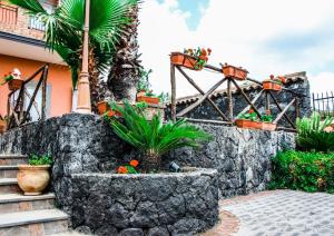 un giardino con pareti in pietra e piante di Martina Paradise Affitta Camere a Nicolosi