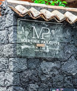 um sinal para uma marina paradisíaca numa parede de pedra em Martina Paradise Affitta Camere em Nicolosi