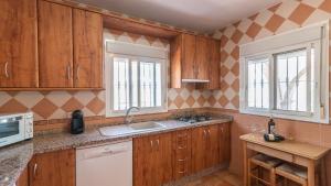 a kitchen with wooden cabinets and a sink at Casa Rural Moreno Canillas de Albaida by Ruralidays in Canillas de Albaida