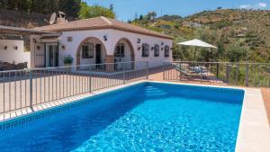 a swimming pool in front of a house at Casa Rural Moreno Canillas de Albaida by Ruralidays in Canillas de Albaida