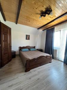 a bedroom with a bed and a wooden ceiling at Nice House in Slavske
