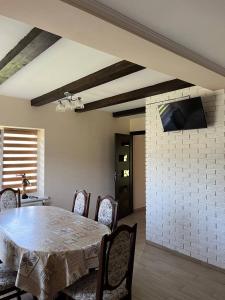 a dining room with a table and a tv on a brick wall at Nice House in Slavske