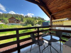 a patio with two chairs and a table on a deck at Nice House in Slavske
