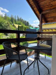 a table and two chairs on a porch with a view at Nice House in Slavske +13 photos