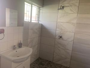a white bathroom with a sink and a shower at Victoria guest house Nyumbani in Tzaneen +39 photos