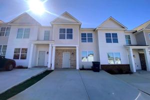 ein großes weißes Haus mit der Sonne am Himmel in der Unterkunft Brand NEW HOME mins to airport in Atlanta