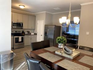a kitchen and dining room with a wooden table and chairs at Brand NEW HOME mins to airport in Atlanta